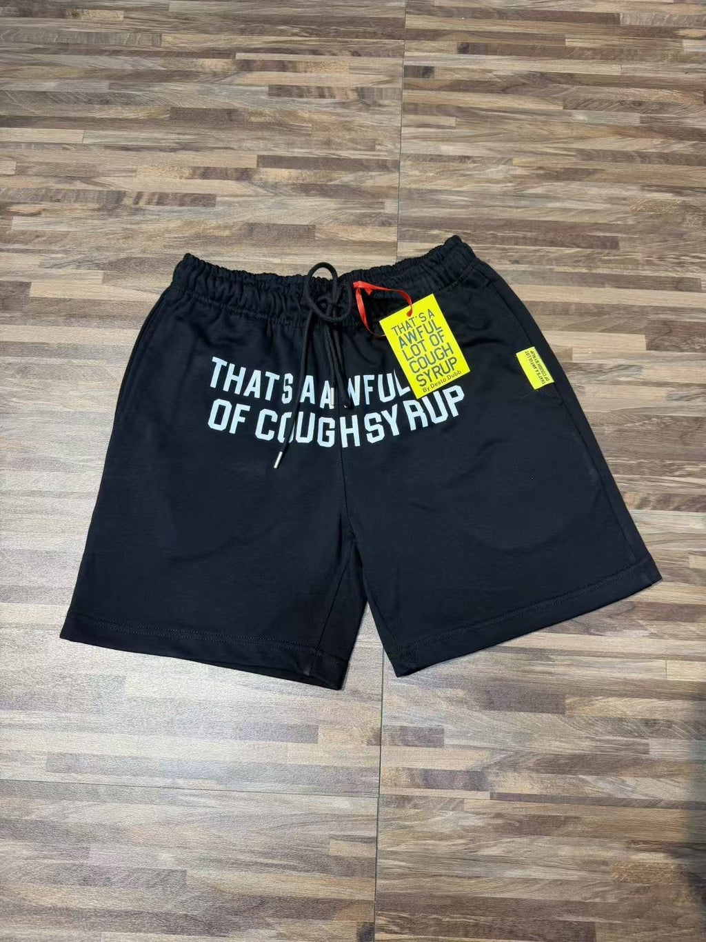 THAT'S A AWFUL LOT OF COUGH SYRUP Black Graphic Shorts — front
