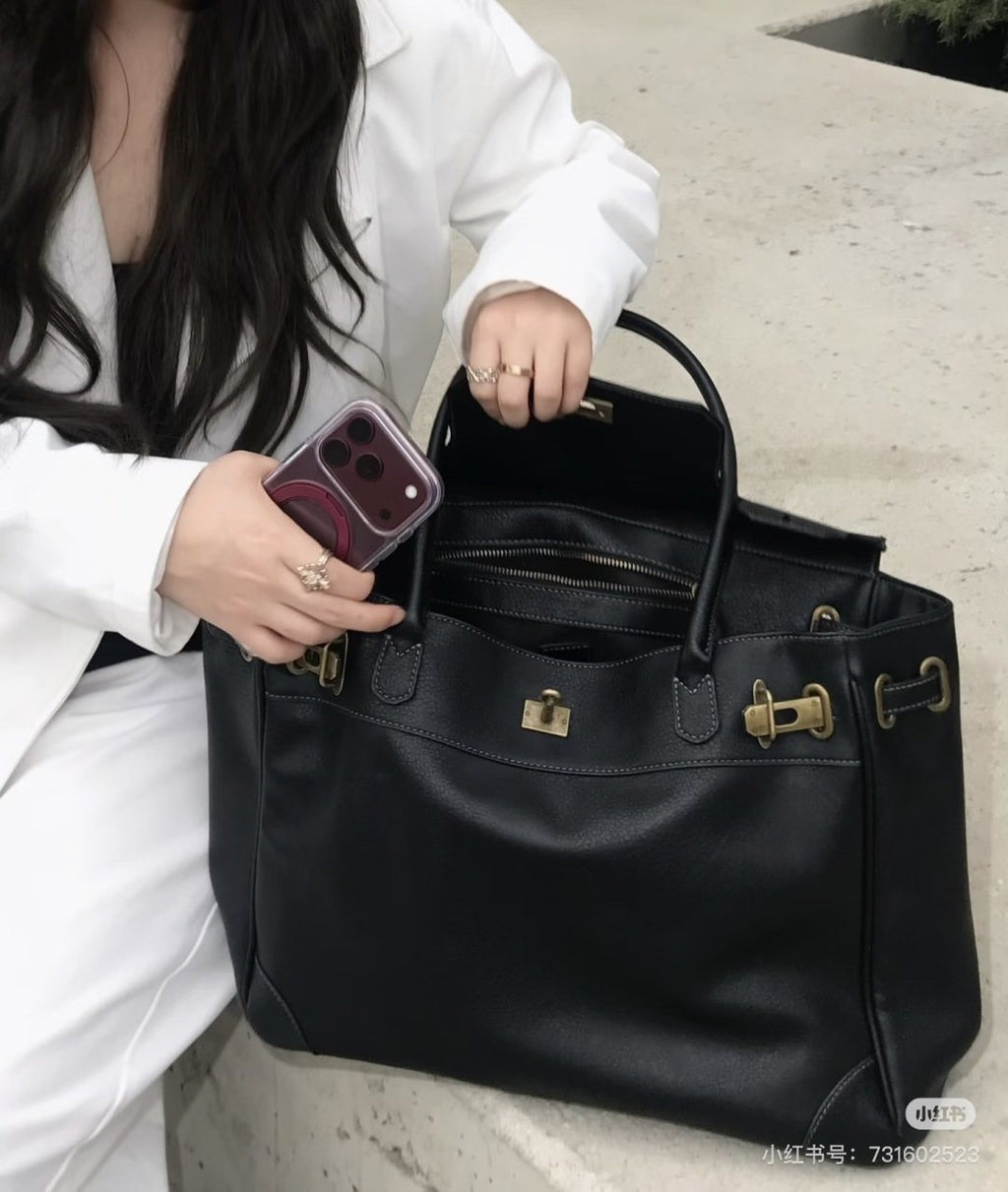 Black Folded-Flap Handbag with Gold-Tone Hardware — model